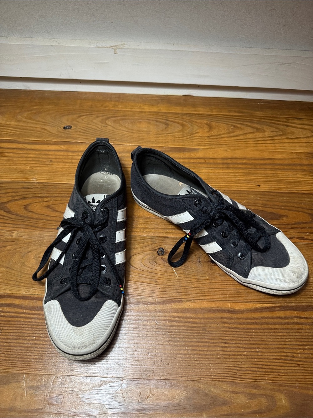 well worn stinky adidas black & white low top sneakers